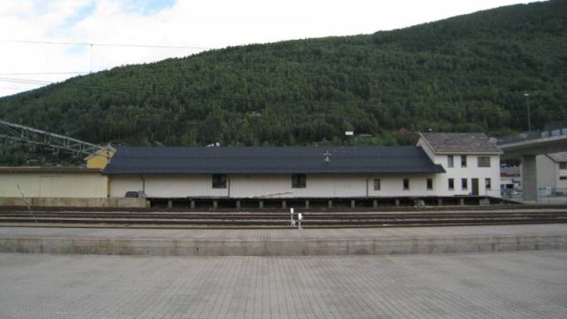 Lagerbygningen med lasterampe ved Otta stasjon. (Fotograf: Dagmar Buen © Fylkesarkivet i Oppland). Bilde av lagerbygning ved Otta stasjon