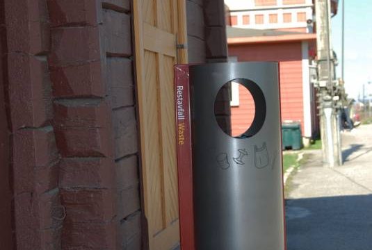 Raufoss stasjon (Fotograf: Solfrid Myhre, (c)Arkivnett Oppland) Bilde av moderne søppelbøtte ved Raufoss stasjon