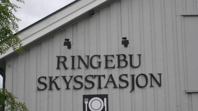 Ringebu skysstasjon. (Fotograf. Dagmar Buen © Fylkesarkivet i Oppland) Bilde av skilt på vegg Ringebu skysstasjon