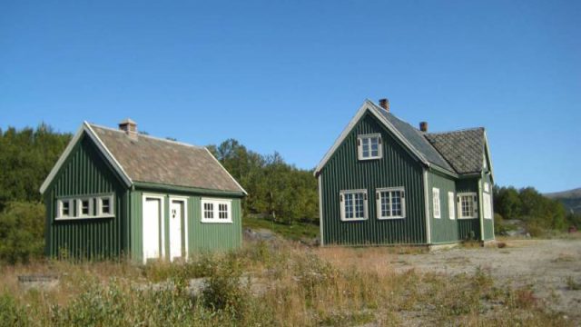 Vålåsjø stasjon, stasjonsbygningen med privetet (utedoen) i forgrunnen (Fotograf: Dagmar Buen © Fylkesarkivet i Oppland). Bilde stasjonsbygning med utedo Vålåsjø stasjon