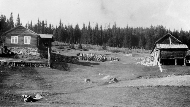 Misjonsmøte på plassen Elidokken under Søre Garli. – Bilde er utlånt av Ola Håvelsrud, Fagernes, via Valdresmusea En gruppe mennesker i distansen mellom to bygninger