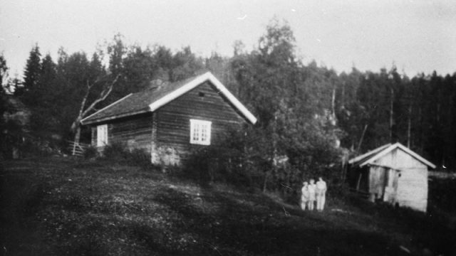 Plassen Sør-Lere under Næs i Brandbu, ca 1930 – Fotograf: Thoralf Kloumanm Foto: Carsten Klouman / Randsfjordmuseene AS Hus, skur/stabbur og 3 personer i distansen