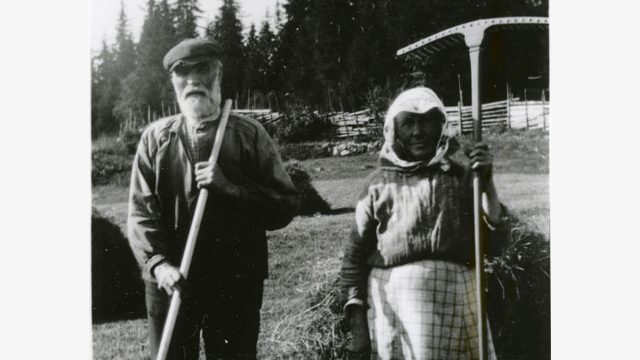 Husmannsfolket på Olimbsbråten – Foto: Randsfjordmuseene AS Eldre mann og kvinne med gårds verktøy